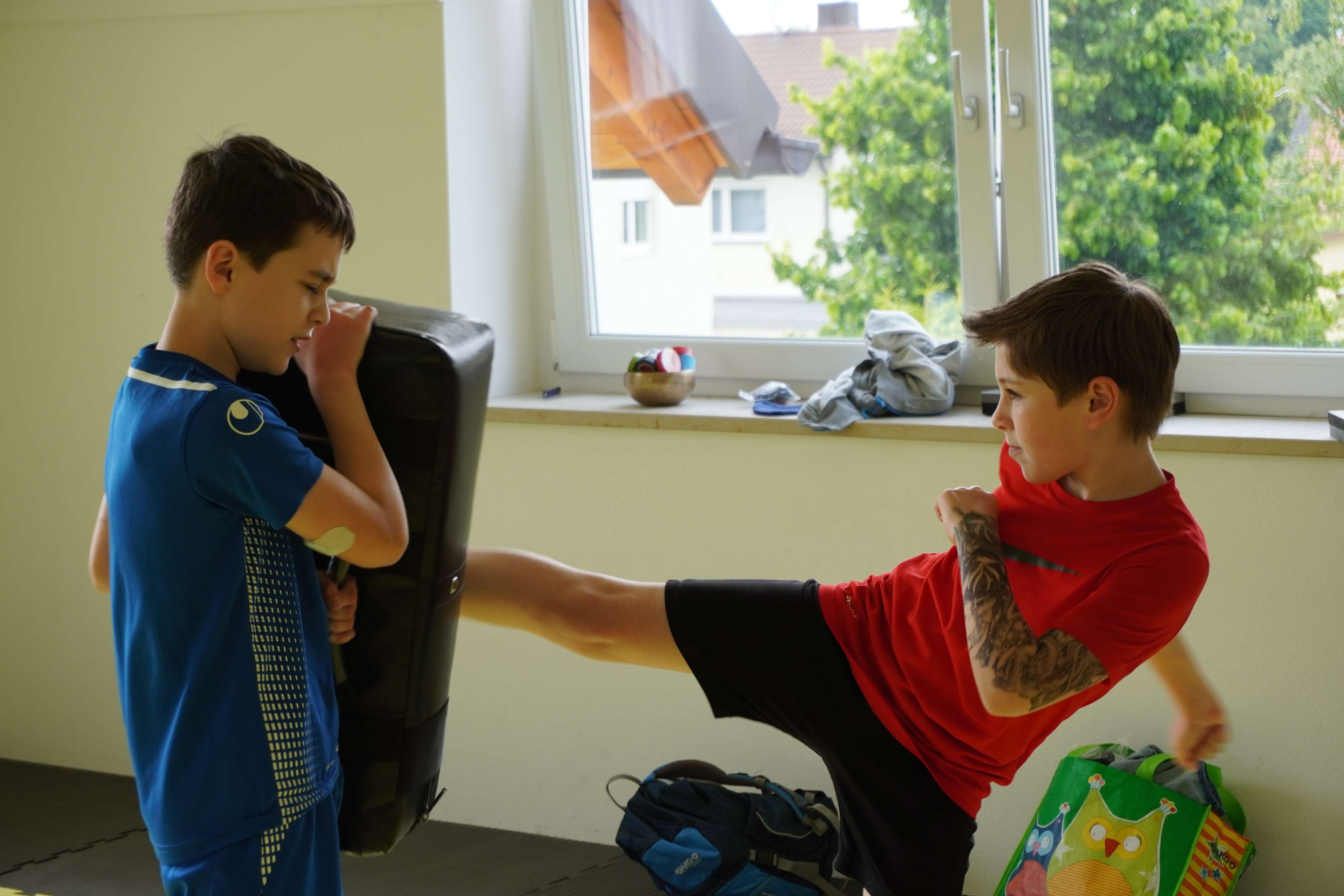 Kinder mit Boxhandschuhen schlagen Pratzen