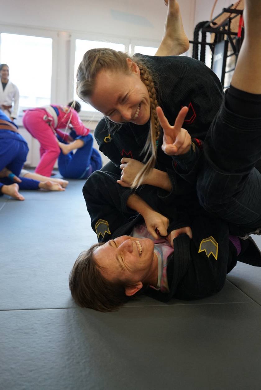 Zwei lachende Mitglieder beim Brazilian-Jiu-Jitsu-Training auf der Matte bei Team Laurien & Alex