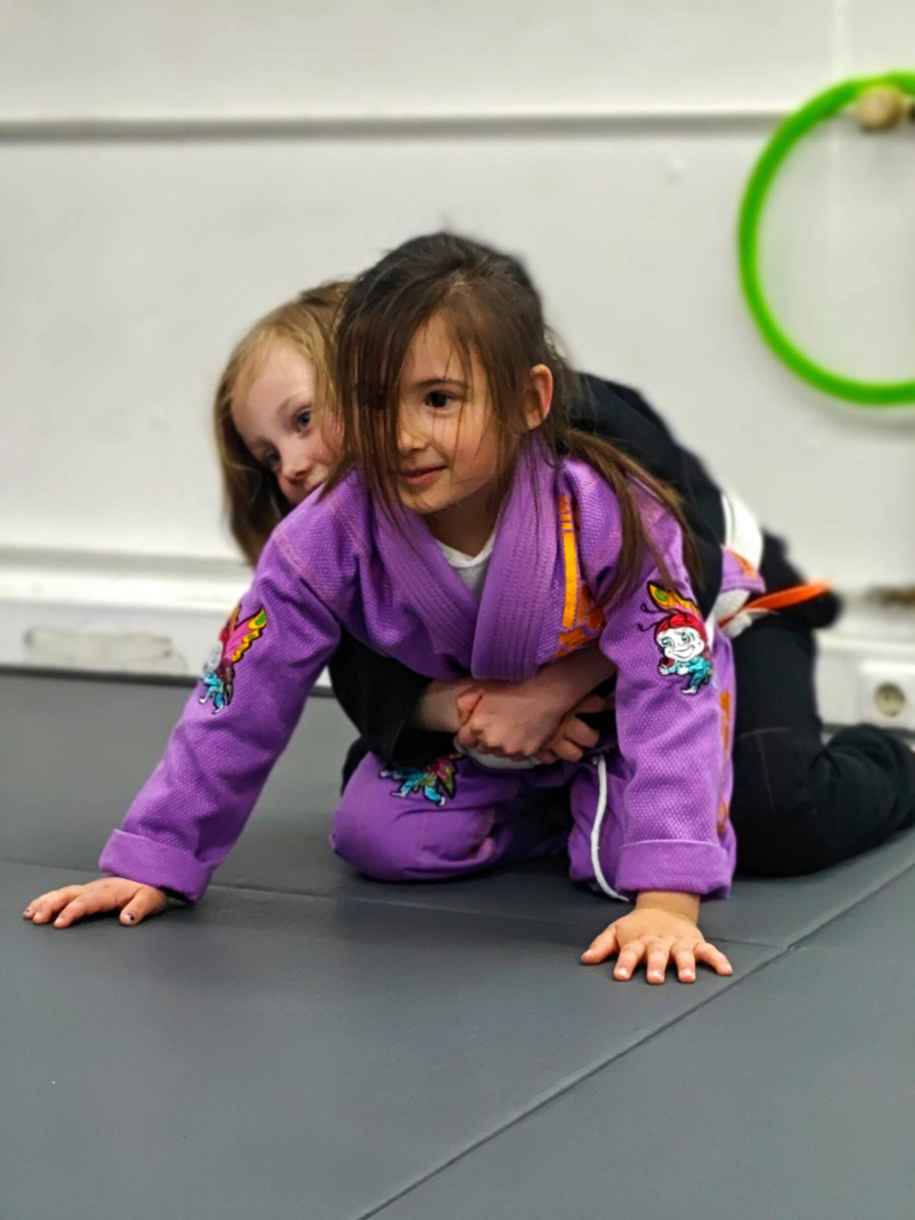 Zwei Kinder üben einen BJJ-Griff auf der Matte bei Team Laurien & Alex in München