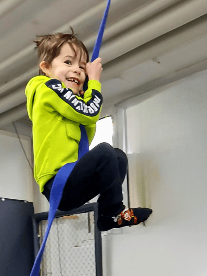 Ein Kind meistert eine Kletteraufgabe im Ninja-Training